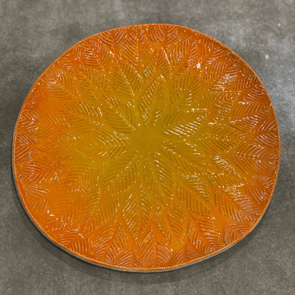Round ceramic plate with textured design  and decorated with Kiwi Underglazes