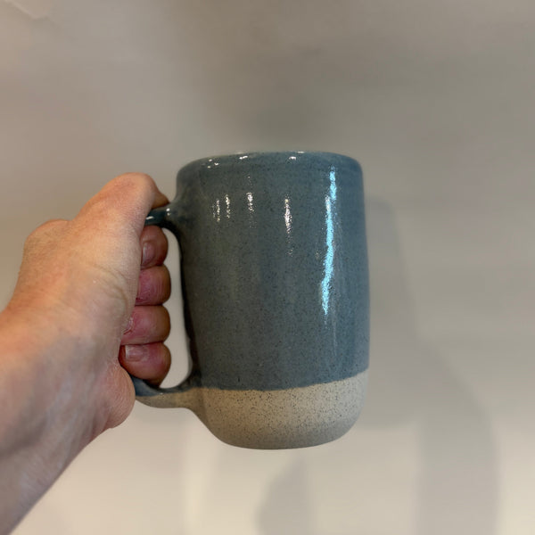 Hand holding a huge blue mug